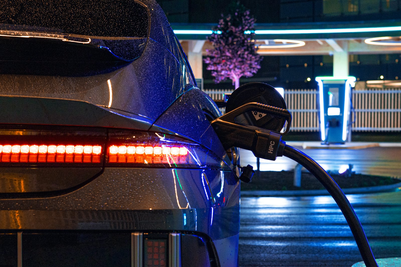 Electric car plugged in at a charging station at night